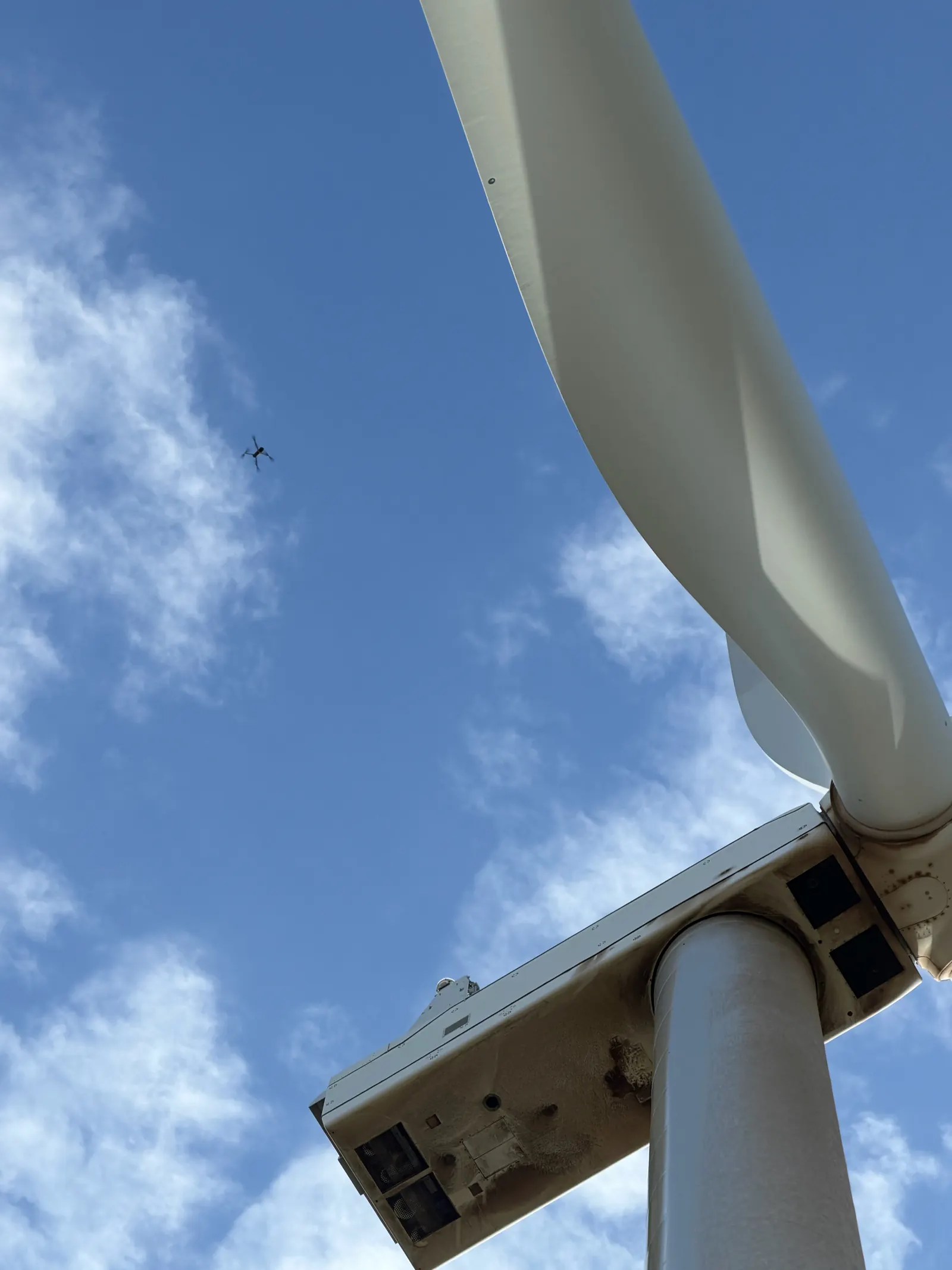Inspection drone inspecting a wind turbine beside the blade and nacelle