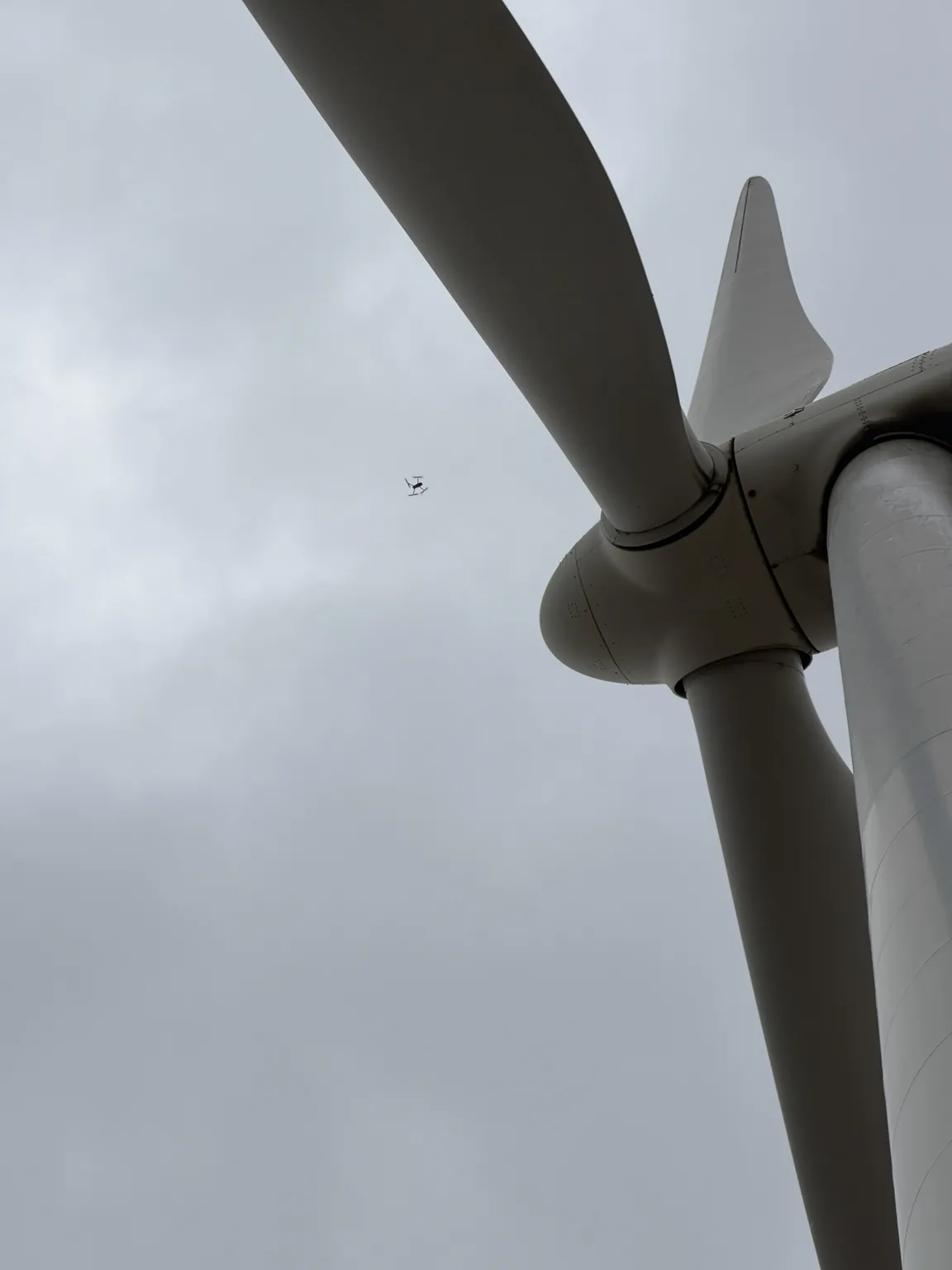 Inspection drone flying beside a wind turbine hub