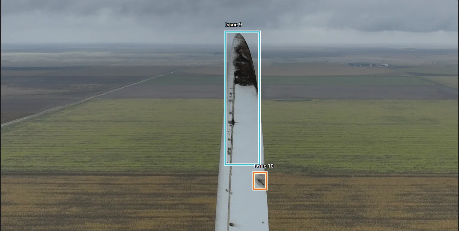 Drone view down a wind turbine blade to an eroded tip over Kansas farmland